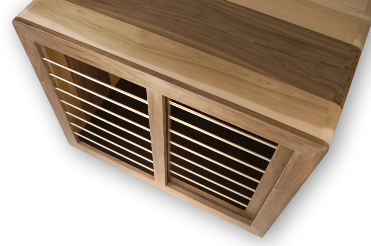 Custom Modern Dog Crate furniture with sleek rounded waterfall edge. over head front cabinet view shown in solid maple and walnut hardwood with sliding door and smooth horizontal steel bars in Champaign color finish